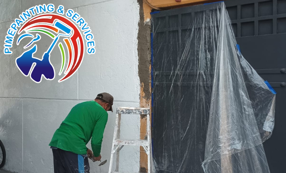 Pintor preparando un portón de metal eliminando el óxido con cepillo de alambre antes de aplicar primer anticorrosivo