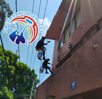 Pintores profesionales aplicando pintura en barda exterior